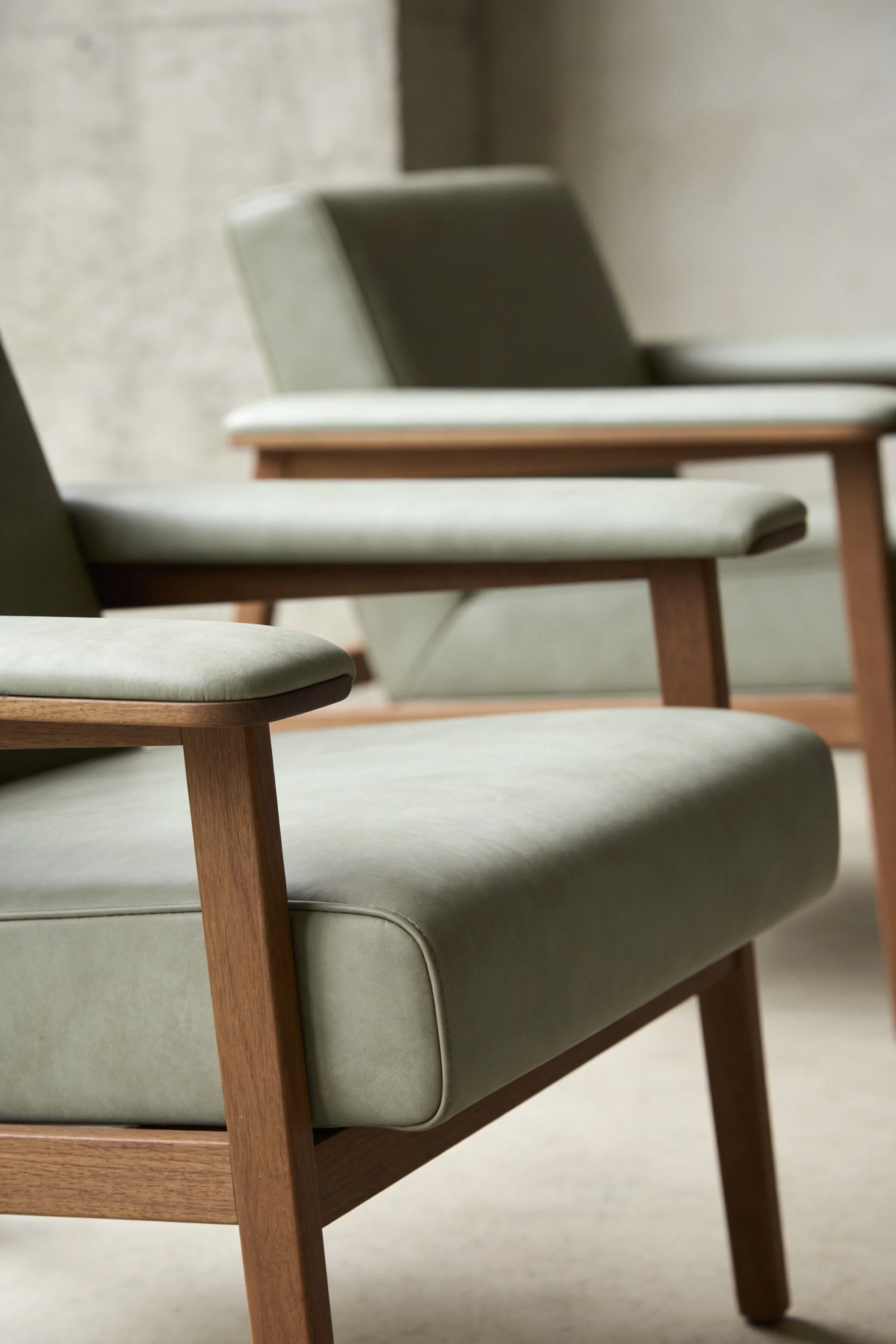 Timber-framed green chairs arranged in a calm dermatology clinic waiting area — Spatial Design by Parallel Creative Agency — Derma, health