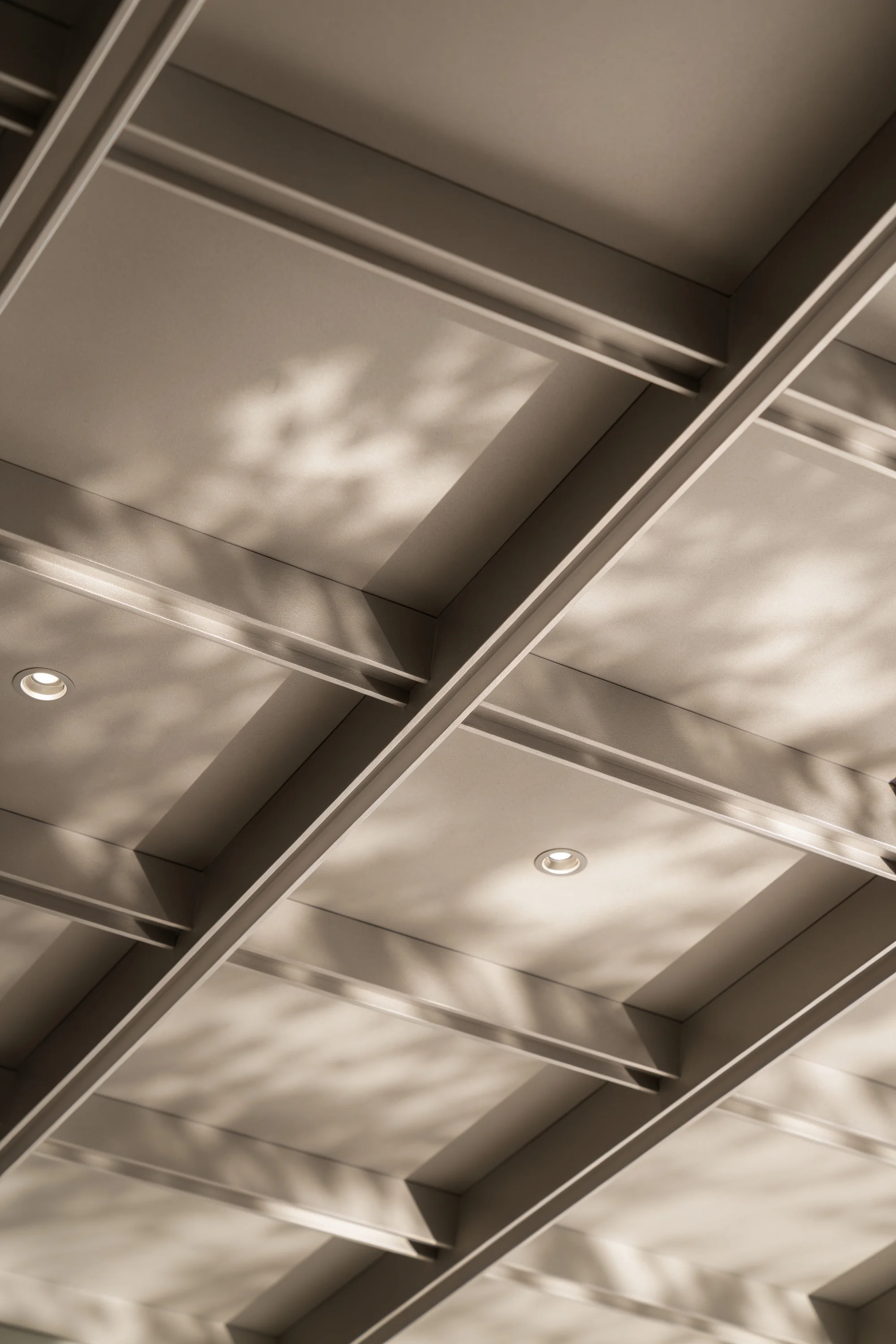 Engineered gridded ceiling with dappled natural light across metallic surfaces — Spatial Design by Parallel Creative Agency — Derma, health