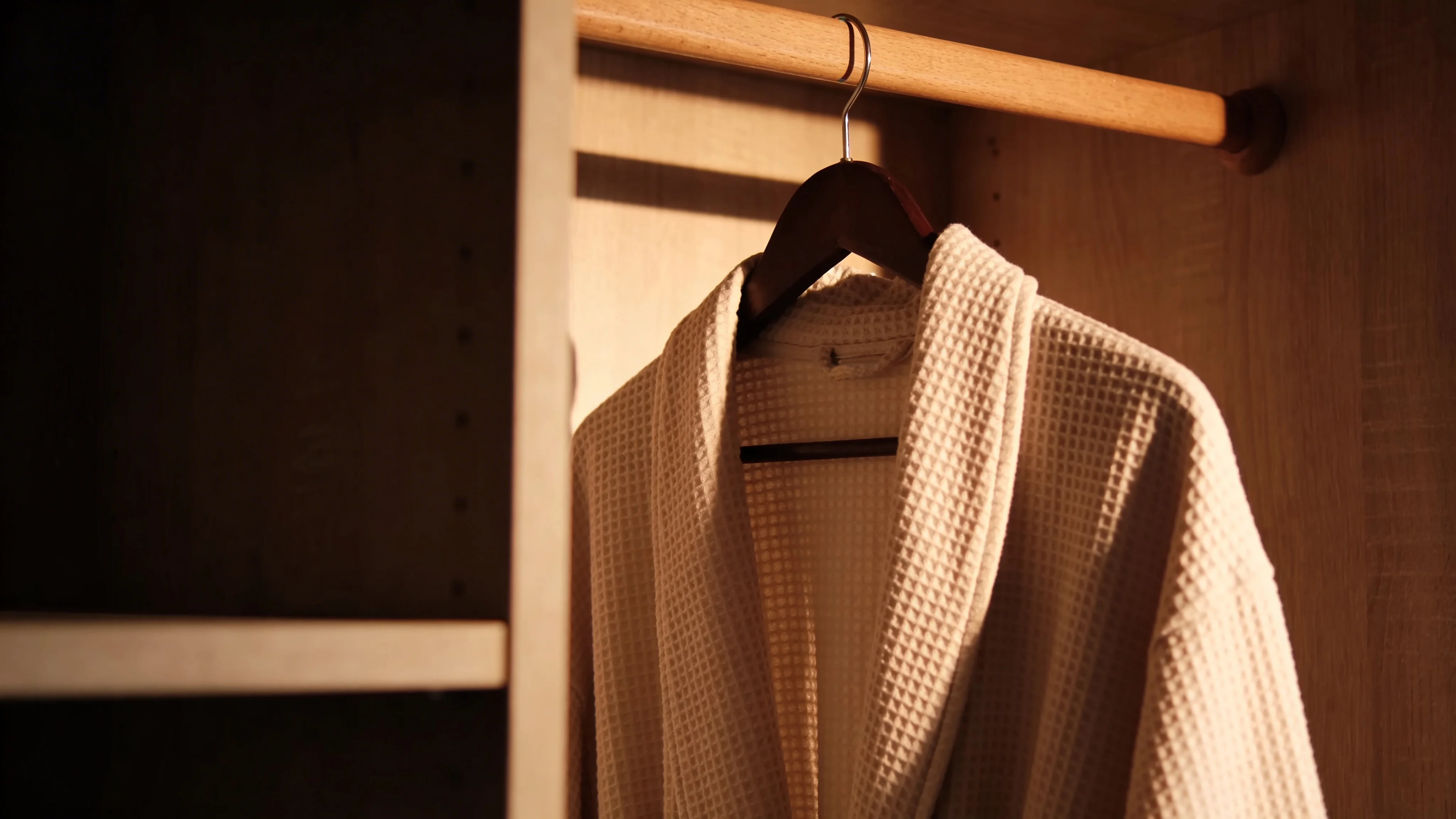 Lento branded bath robe hanging in open wardrobe — Brand Identity by Parallel Creative Agency — Lento, hospitality