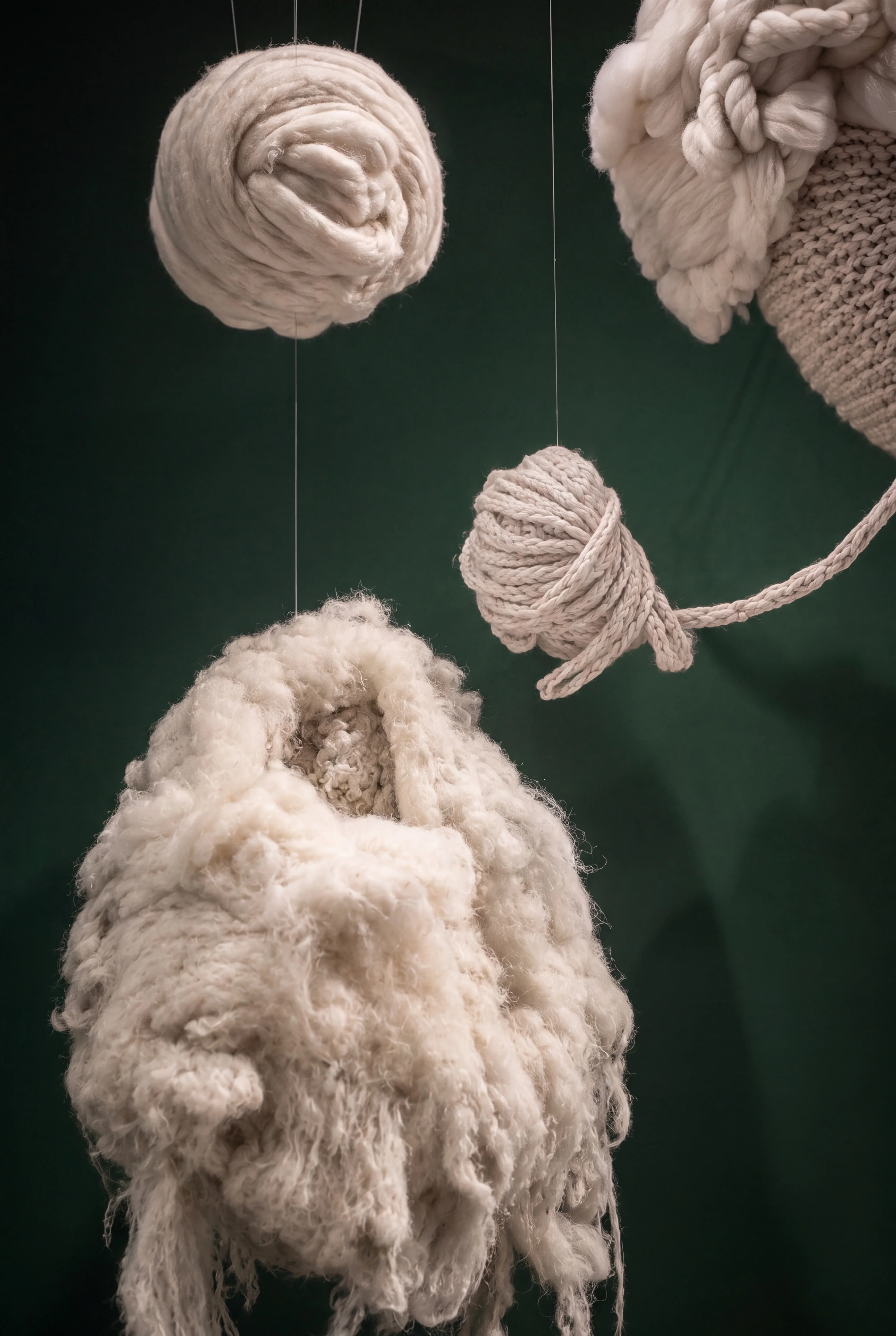 Close-up of raw fleece, spun wool and knitted textile forms suspended in the Tweed display — Window Concept by Parallel Creative Agency — Loom, fashion