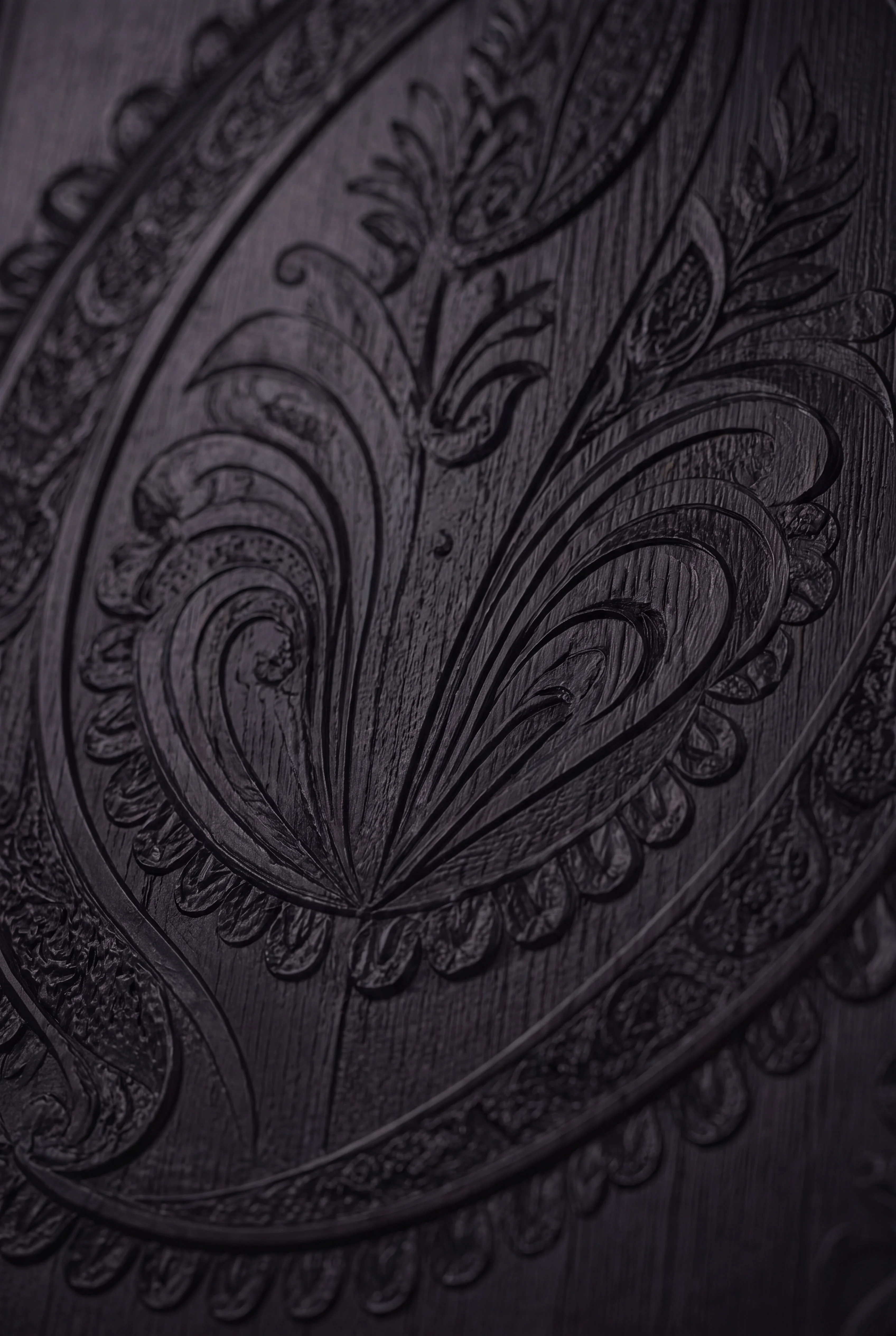 Close-up of an embossed Paisley motif across the dark exhibition wall — Interiors by Parallel Creative Agency — Loom, culture