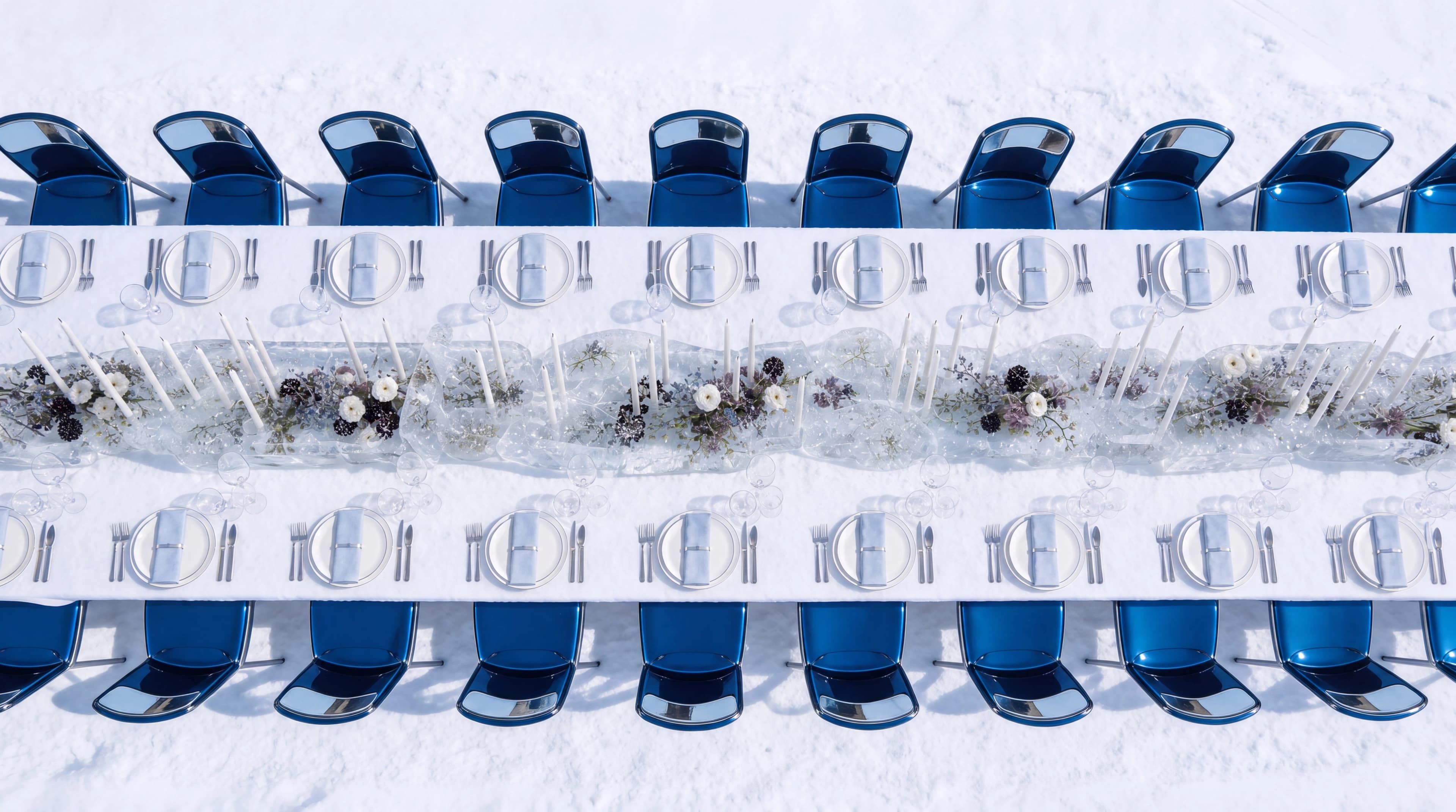 Overhead view of a formal glacier table with blue chairs and transparent place settings — Spatial Design by Parallel Creative Agency — Uncharted Table, hospitality