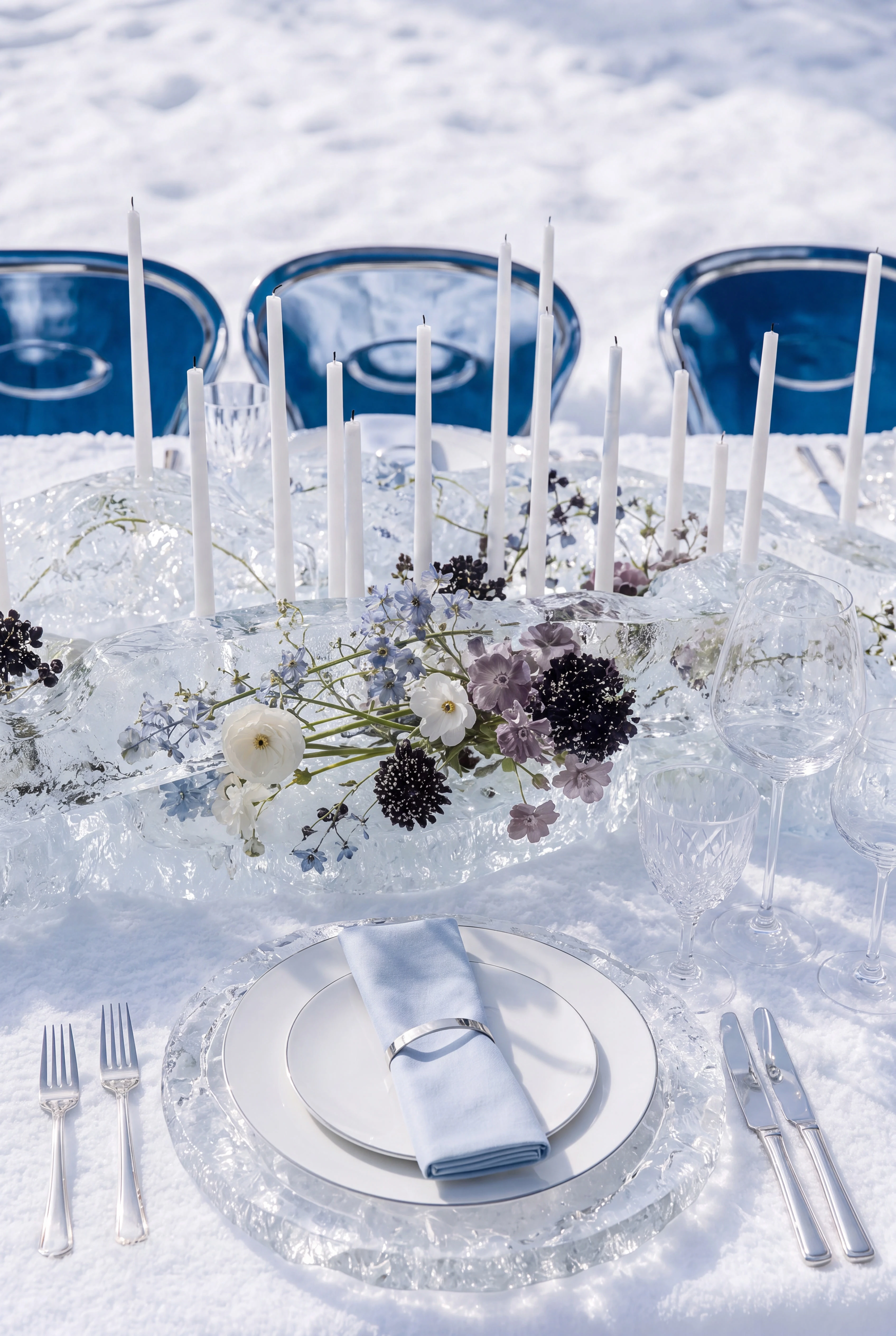 Snow dining place setting framed by blue chairs, white candles and mountain terrain — Spatial Design by Parallel Creative Agency — Uncharted Table, hospitality
