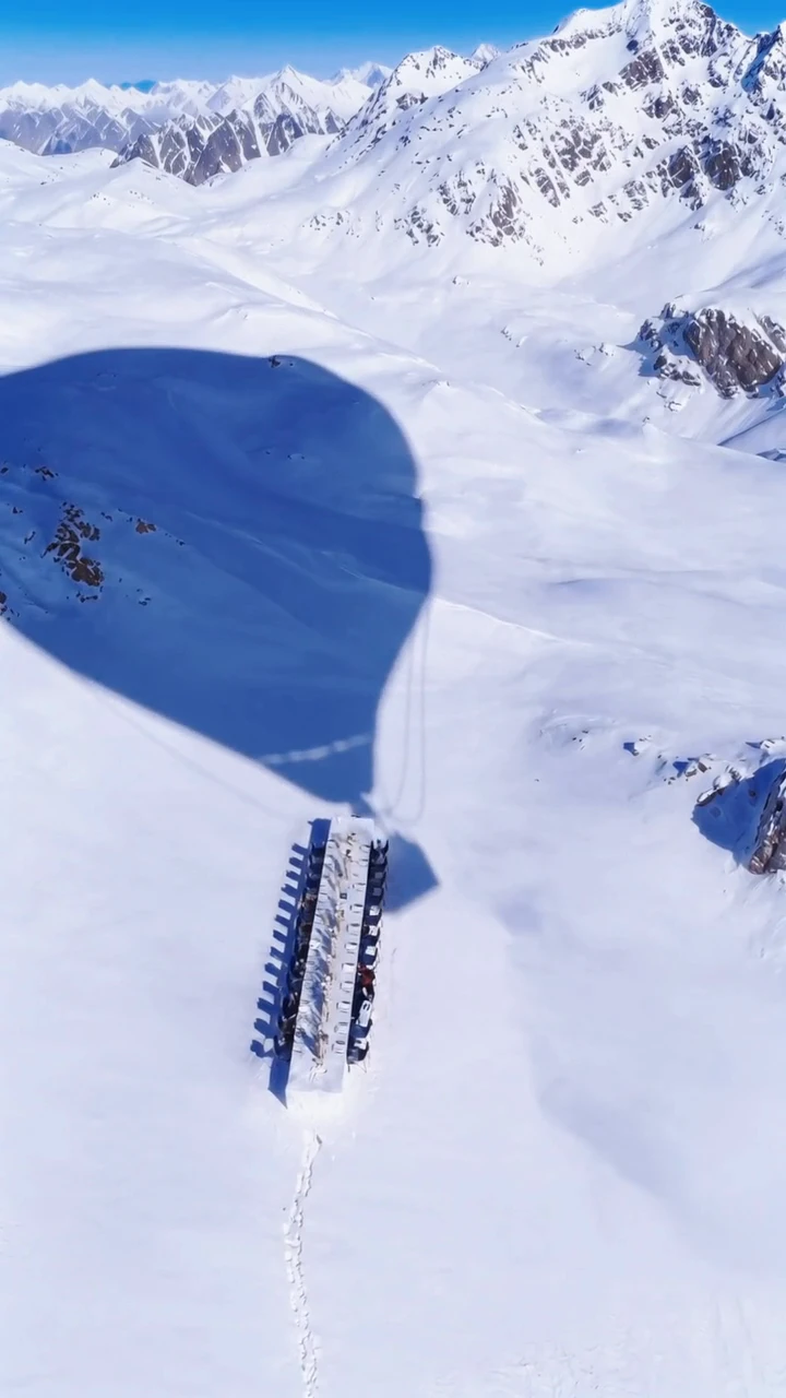 Uncharted Table hero video: an aerial view of a hot air balloon's shadow over a remote glacier dining table